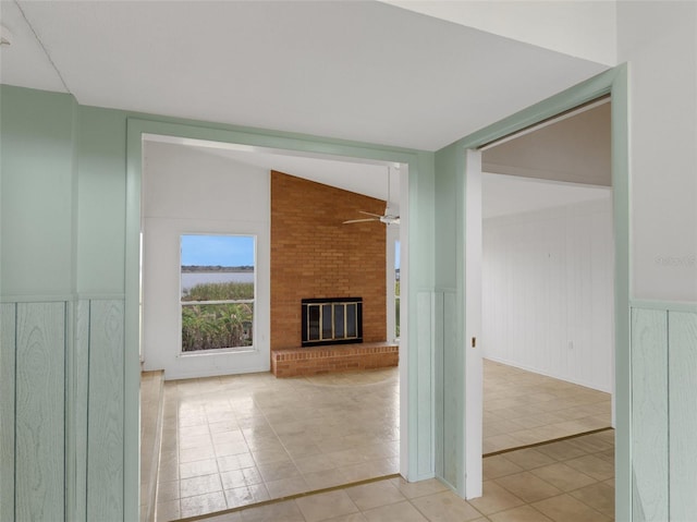 hallway featuring lofted ceiling and light tile patterned flooring