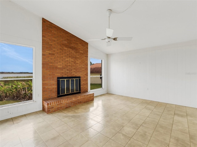 unfurnished living room featuring light tile patterned floors, a brick fireplace, ceiling fan, and vaulted ceiling