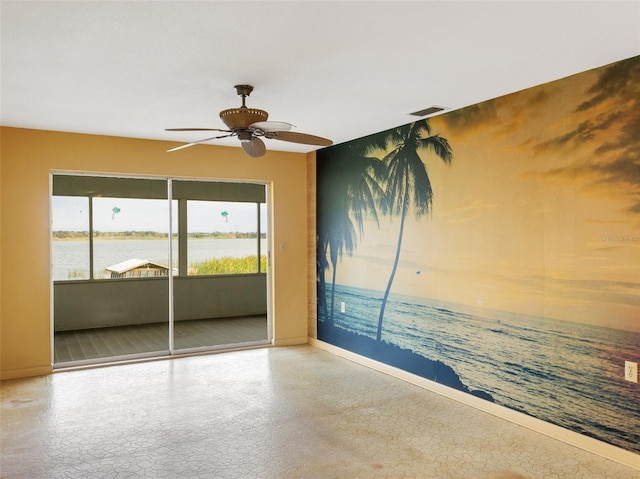 spare room with ceiling fan and a water view