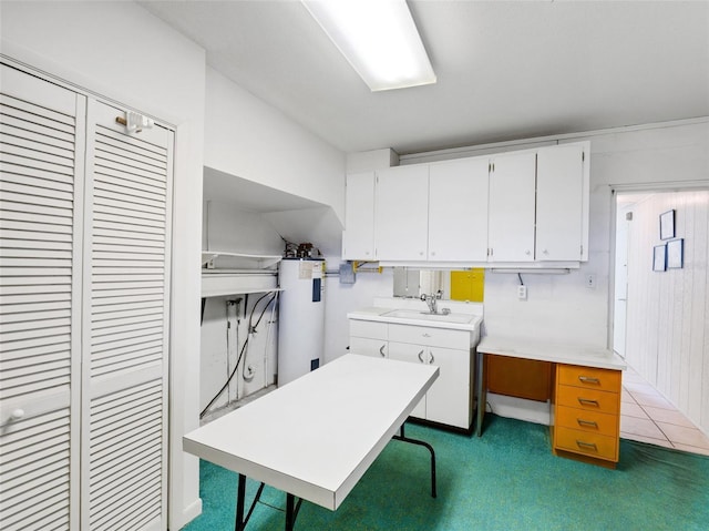 interior space featuring white cabinets, water heater, sink, and dark colored carpet