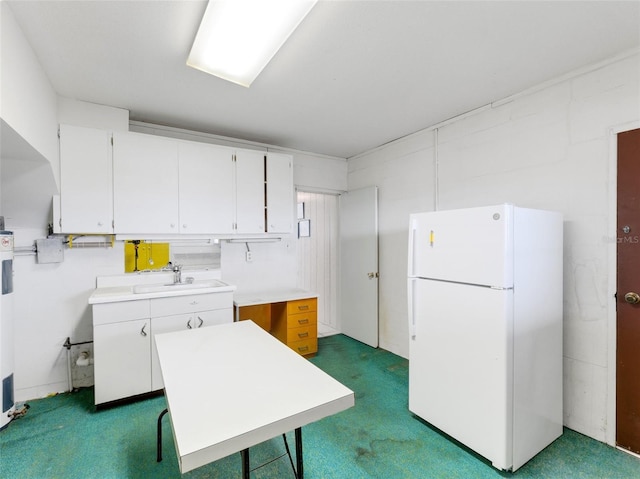 kitchen with sink, white cabinets, white fridge, and dark carpet