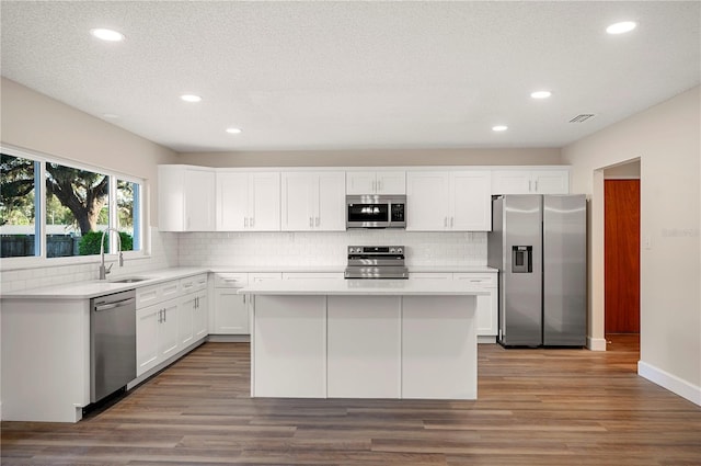 kitchen with white cabinetry, sink, a kitchen island, and appliances with stainless steel finishes