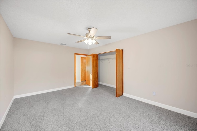 unfurnished bedroom with ceiling fan, light colored carpet, and a closet