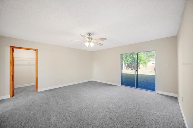 carpeted empty room featuring ceiling fan and a textured ceiling