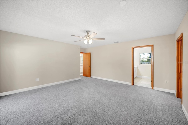 spare room with light carpet, ceiling fan, and a textured ceiling