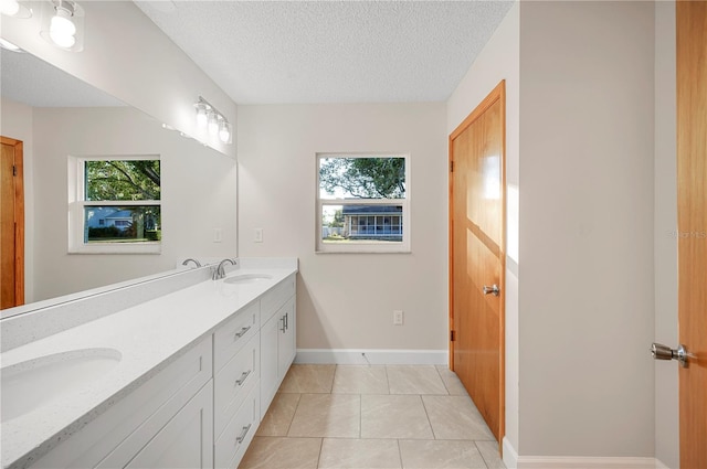 bathroom featuring tile patterned flooring, vanity, and a textured ceiling