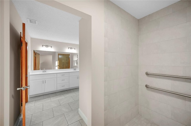 bathroom featuring tile patterned floors, vanity, and a textured ceiling