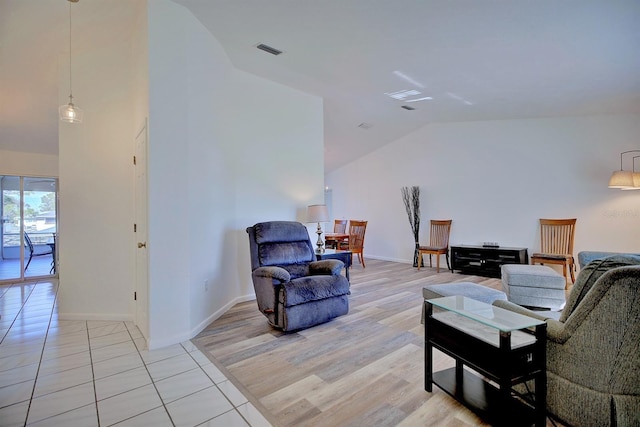 living room featuring vaulted ceiling and light hardwood / wood-style flooring