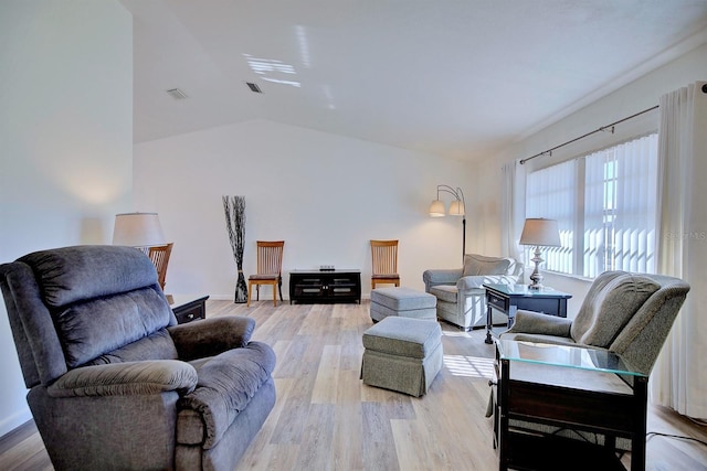 living room featuring lofted ceiling and light wood-type flooring