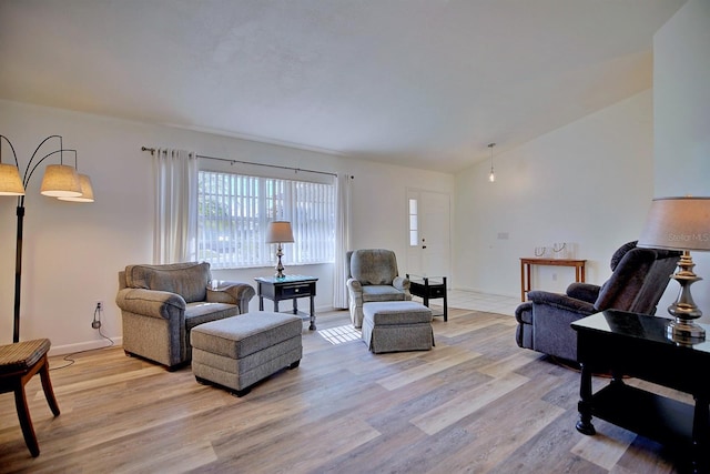 living room with vaulted ceiling and light hardwood / wood-style flooring