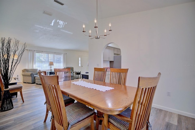 dining area with a notable chandelier and light hardwood / wood-style flooring