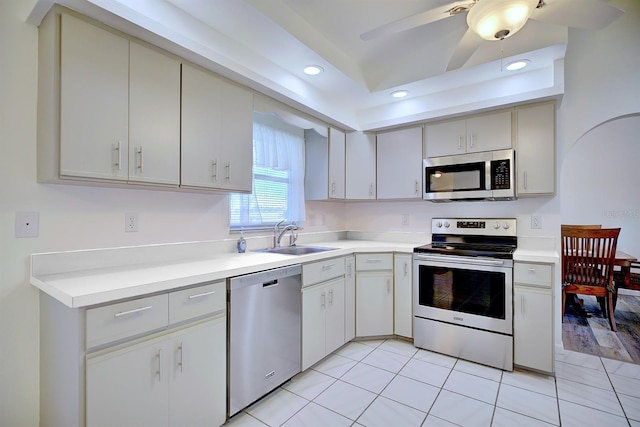 kitchen with appliances with stainless steel finishes, sink, light tile patterned floors, and ceiling fan