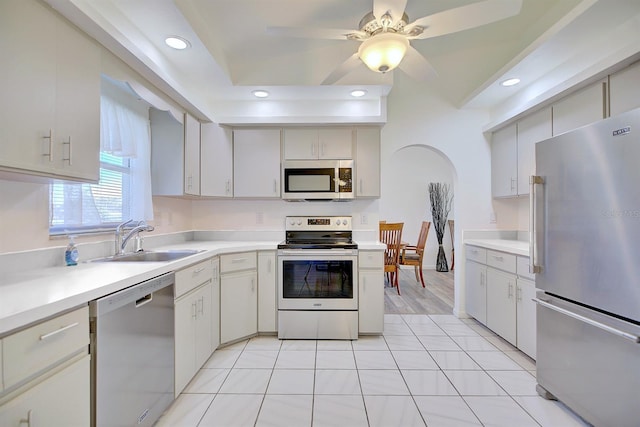 kitchen with stainless steel appliances, white cabinetry, sink, and ceiling fan