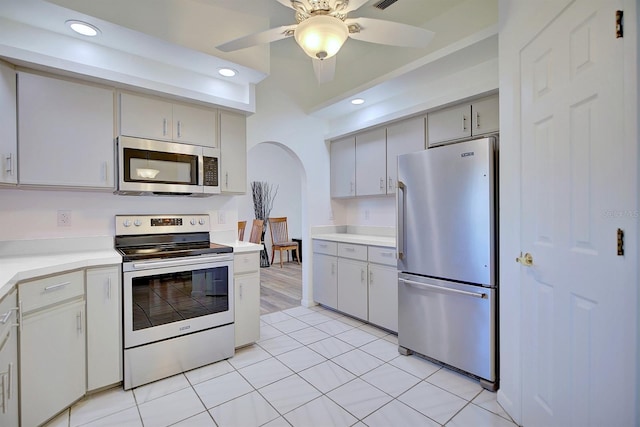 kitchen with stainless steel appliances, light tile patterned floors, and ceiling fan