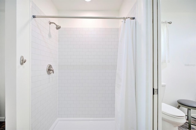 bathroom featuring a shower with curtain and toilet