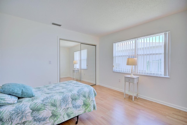 bedroom featuring a closet, hardwood / wood-style floors, and a textured ceiling