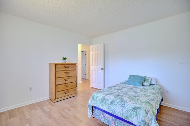 bedroom featuring a textured ceiling and light hardwood / wood-style floors