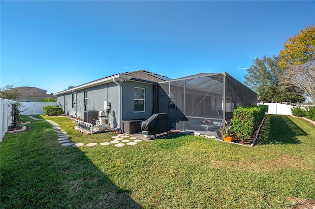 back of property with a yard and a lanai