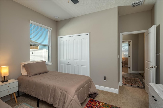 carpeted bedroom featuring ceiling fan and a closet