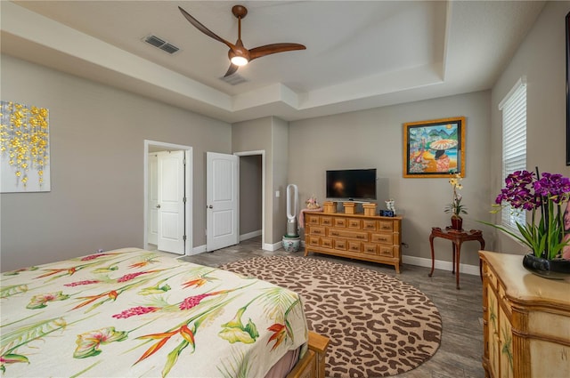 bedroom with ceiling fan and a raised ceiling