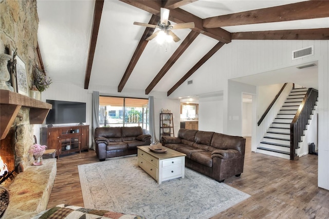 living room featuring wood-type flooring, beamed ceiling, high vaulted ceiling, and ceiling fan