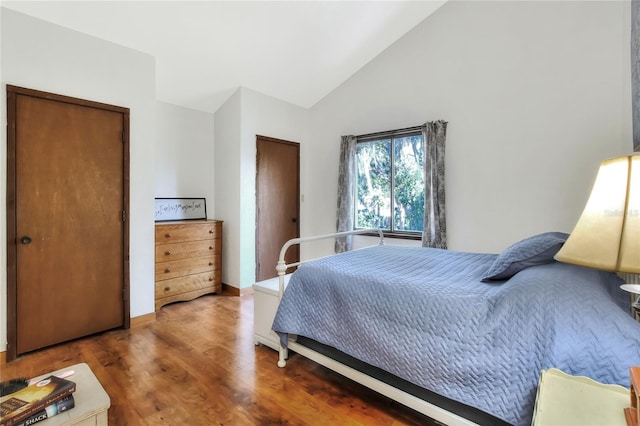 bedroom with vaulted ceiling and dark hardwood / wood-style flooring