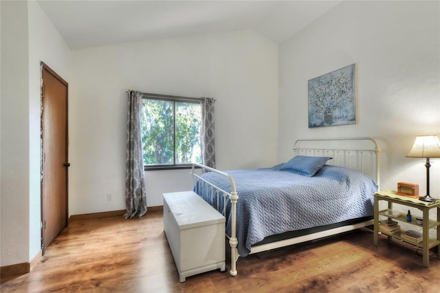 bedroom featuring hardwood / wood-style floors and lofted ceiling