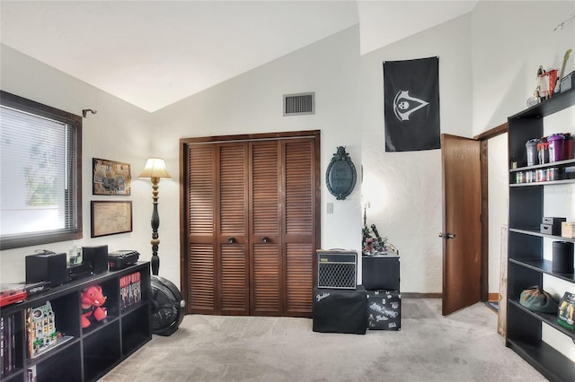 interior space featuring light colored carpet, a closet, and lofted ceiling