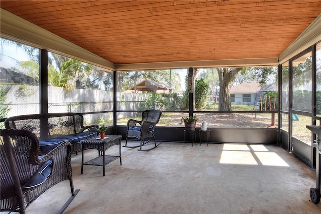 unfurnished sunroom featuring wooden ceiling, a healthy amount of sunlight, and vaulted ceiling