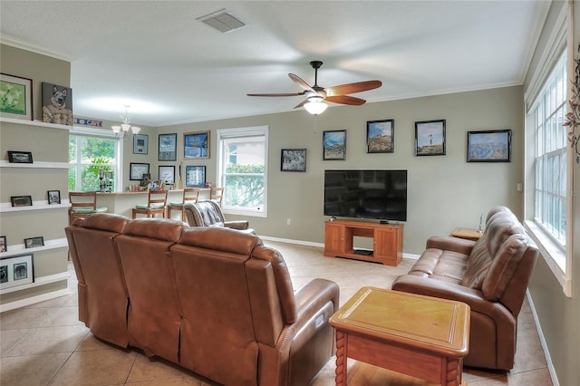 living room featuring crown molding, ceiling fan with notable chandelier, and light tile patterned floors