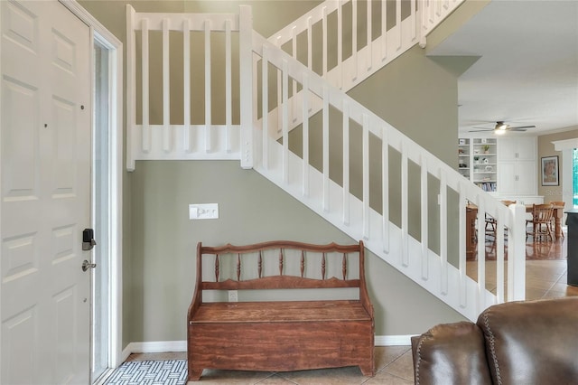 stairs featuring tile patterned floors and ceiling fan