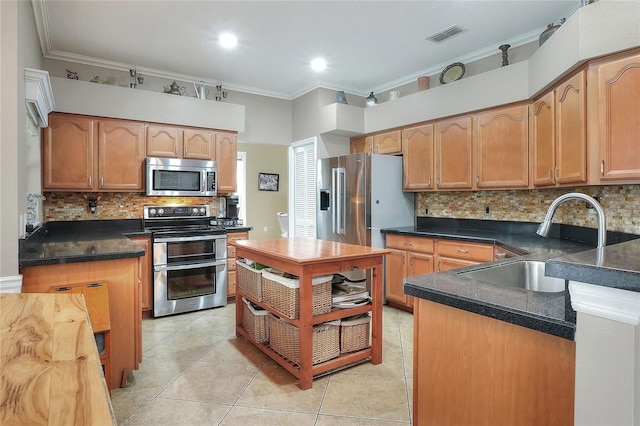 kitchen featuring crown molding, sink, light tile patterned floors, and appliances with stainless steel finishes