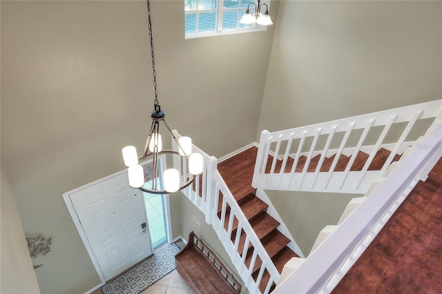 staircase with a chandelier and tile patterned flooring