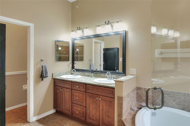 bathroom featuring tiled tub, vanity, and tile patterned floors