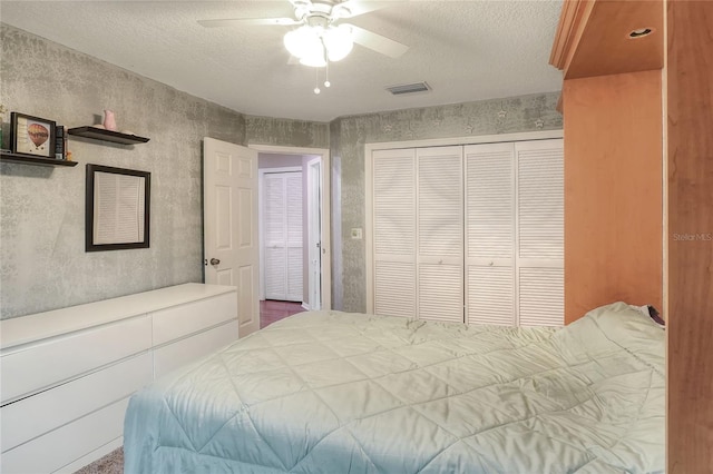 bedroom with ceiling fan, a textured ceiling, and a closet