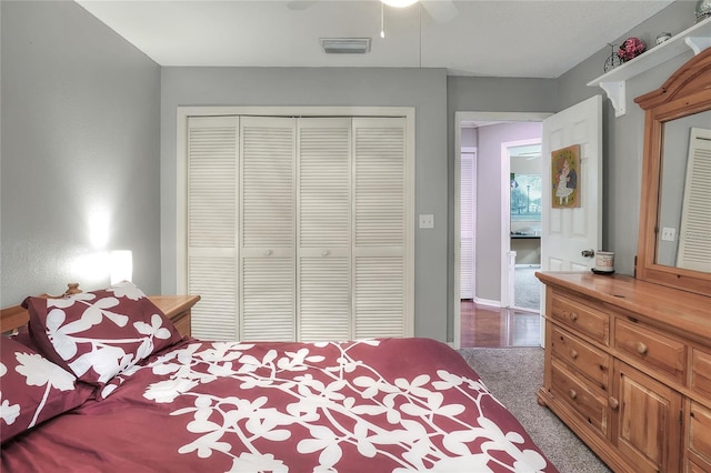 carpeted bedroom with ceiling fan and a closet