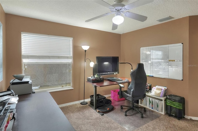 home office with ceiling fan, carpet flooring, and a textured ceiling