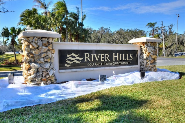 community / neighborhood sign featuring a lawn