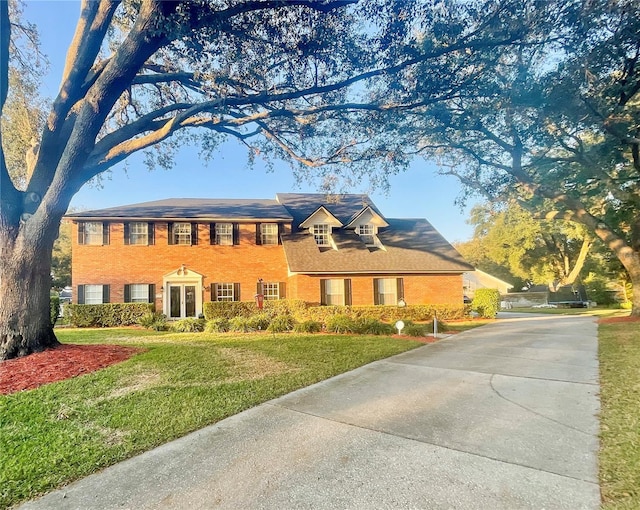 colonial-style house featuring a front lawn