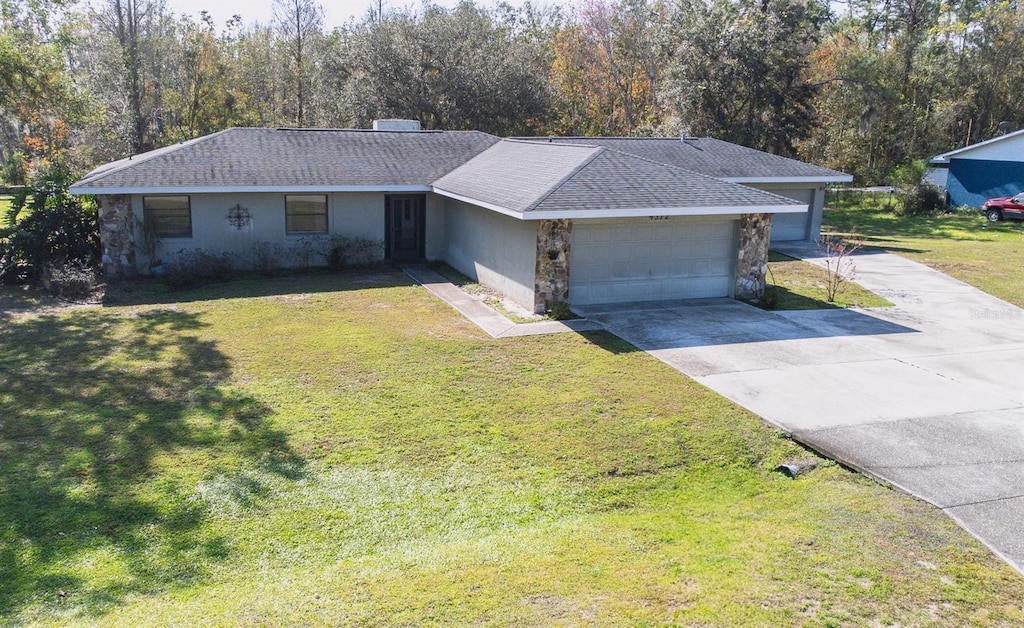 single story home featuring a garage and a front lawn