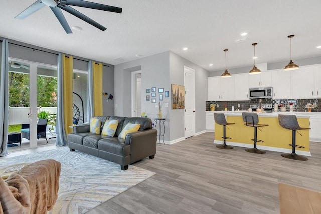 living room featuring light hardwood / wood-style floors, ceiling fan, a textured ceiling, and french doors