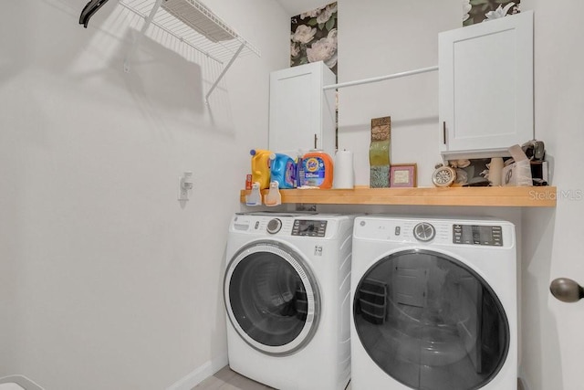 laundry room featuring cabinets and washer and dryer