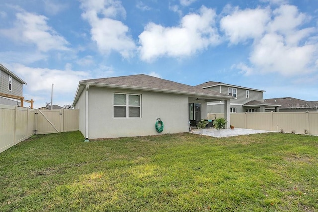 rear view of property with a yard and a patio