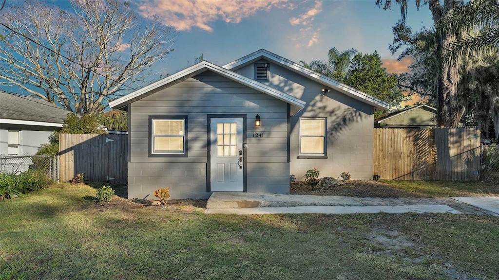 bungalow-style house with a lawn