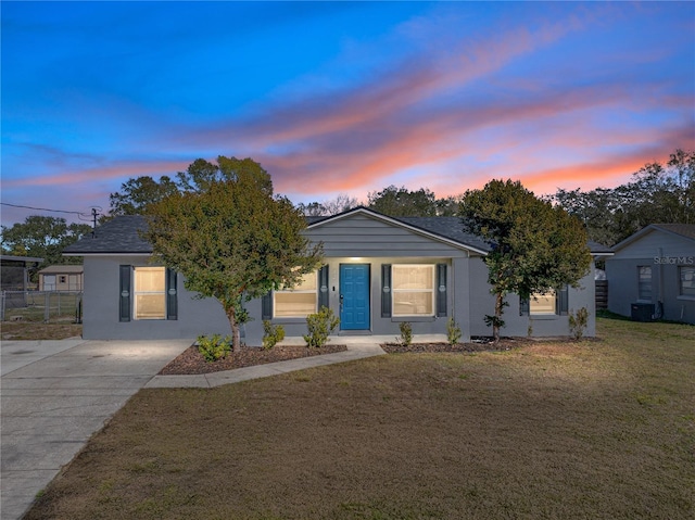 ranch-style house featuring a yard and central AC