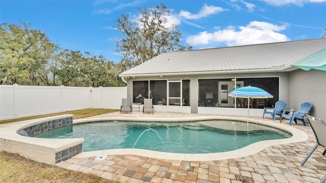 view of pool with pool water feature, a sunroom, and a patio area