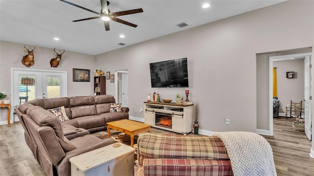 living room with ceiling fan, light wood-type flooring, and french doors