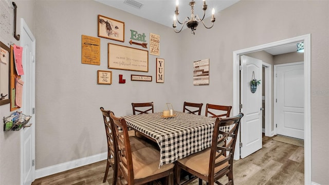 dining area with hardwood / wood-style flooring and a chandelier