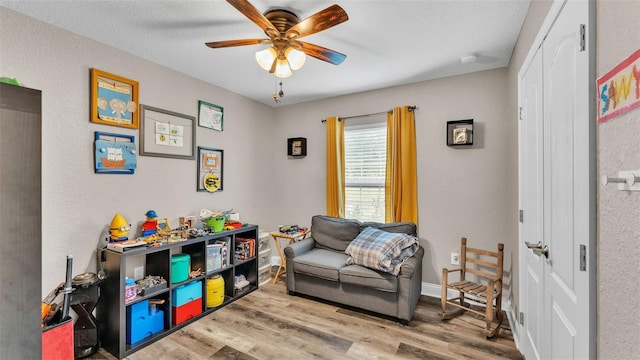 sitting room with light hardwood / wood-style flooring and ceiling fan