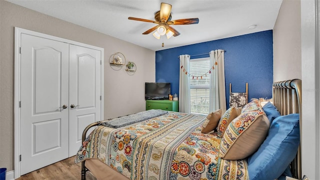 bedroom featuring hardwood / wood-style flooring, ceiling fan, and a closet